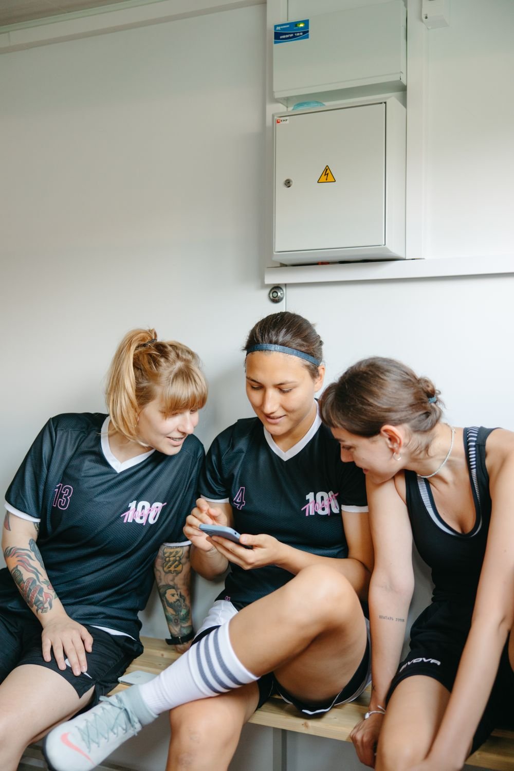 Jugadoras consultando el móvil en el vestuario antes del entrenamiento