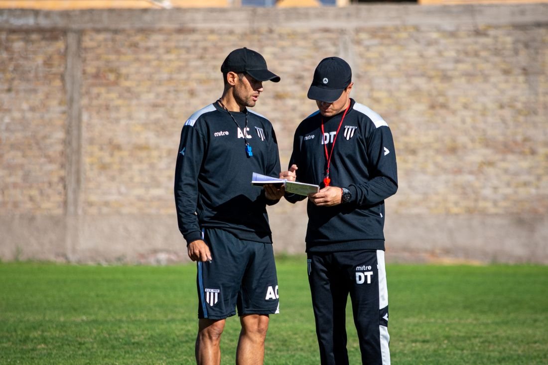 Dos miembros del cuerpo técnico revisando los datos de la sesión a pie de campo